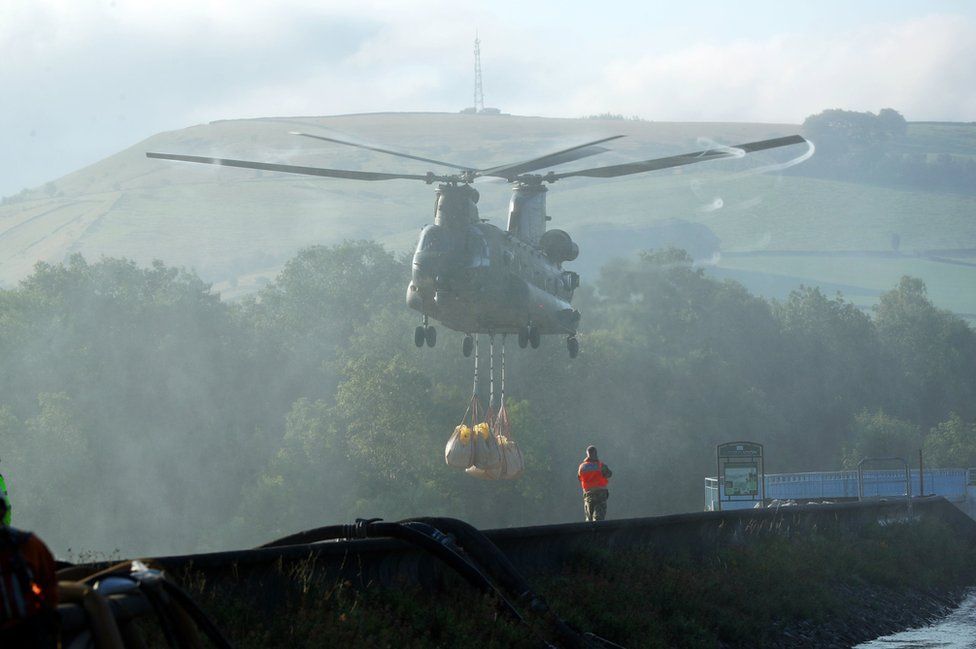 RAF helicopter dropping aggregates to reinforce the damaged section of the dam